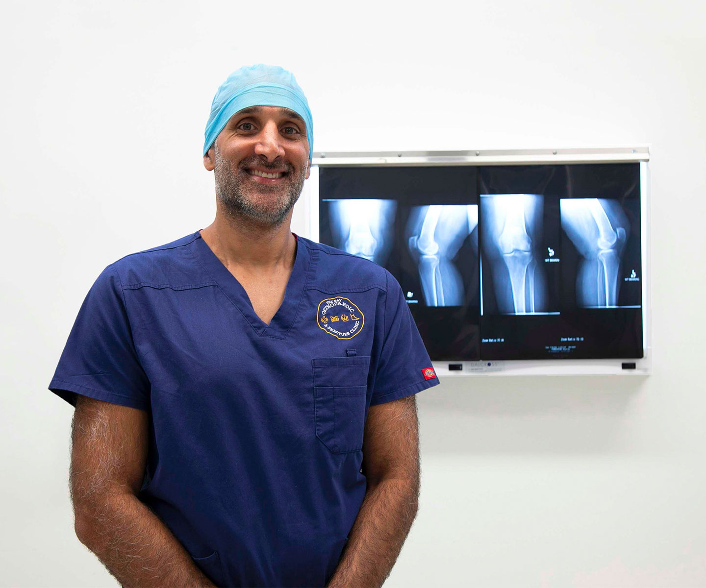 Dr Navi Bali - orthopaedic surgeon in Hervey Bay standing in front of knee xrays